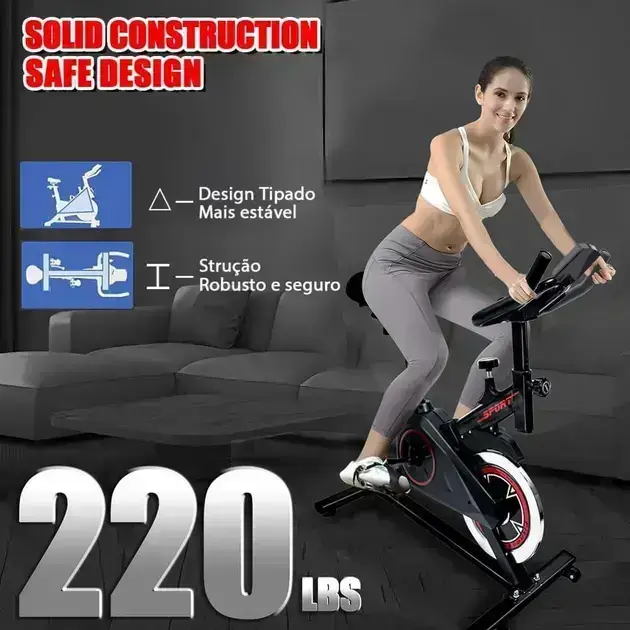 Bicicleta em perspectiva lateral em uma sala de estar com sofá cinza.