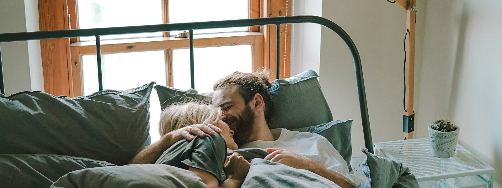 man kissing woman on her forehead