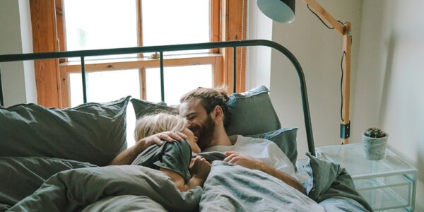 man kissing woman on her forehead